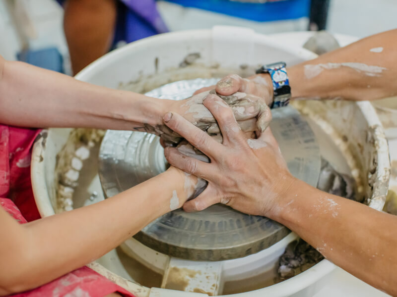 Two hands on a pottery wheel